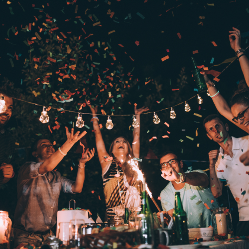 People celebrating with confetti and sparklers at a party.